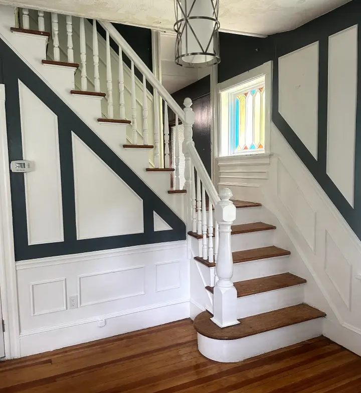 A staircase with wood floors and white walls.