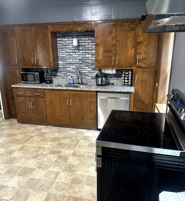 A kitchen with wood cabinets and black appliances.