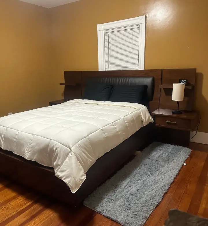 A bed room with a neatly made bed and two nightstands