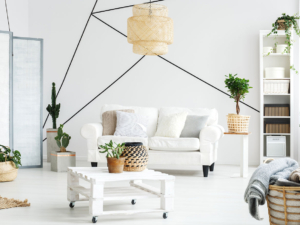 A living room with white furniture and plants.