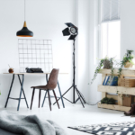 A room with a desk, chair and lamp.