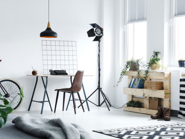 A room with a desk, chair and lamp.