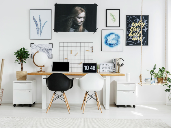 A room with two desks and a laptop on it