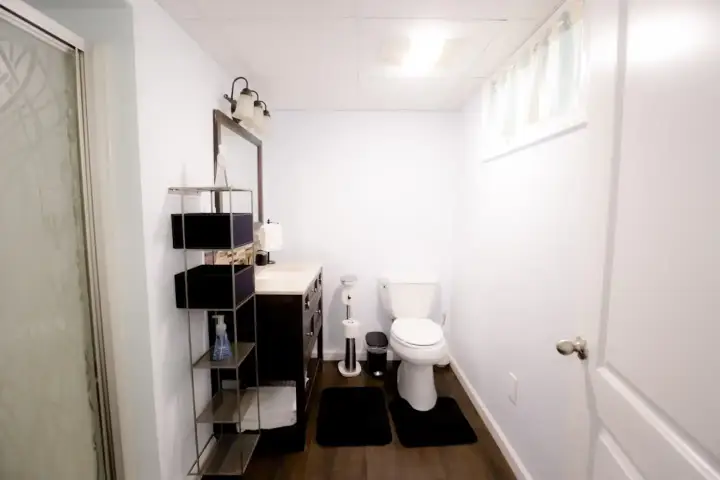 A bathroom with white walls and black floors.