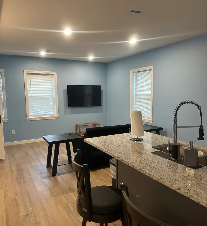 A kitchen with a sink, counter and television.