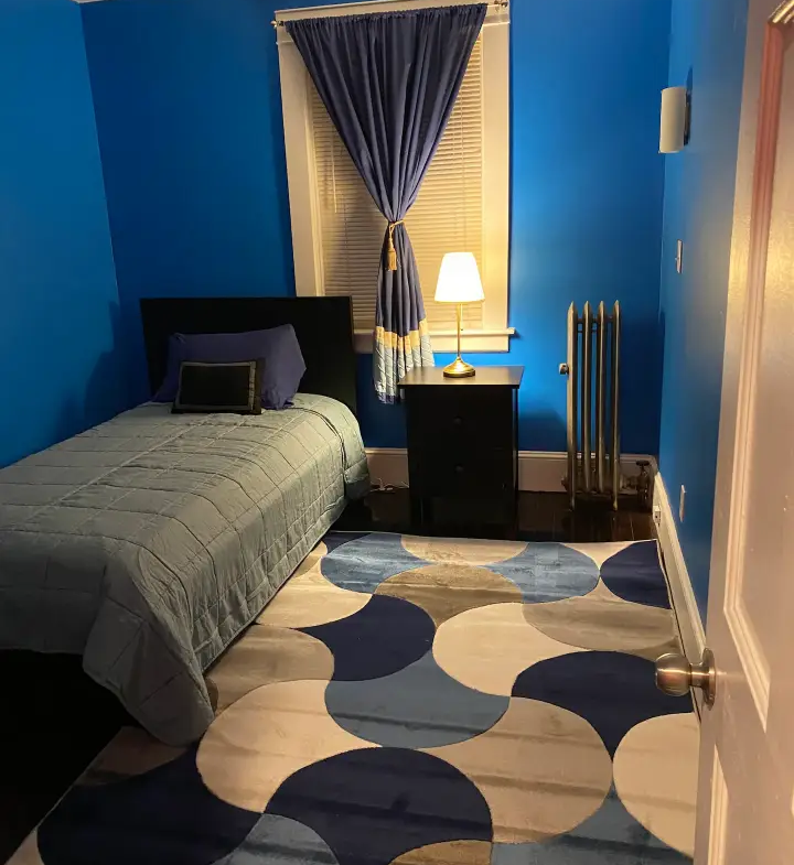 A bedroom with blue walls and a bed