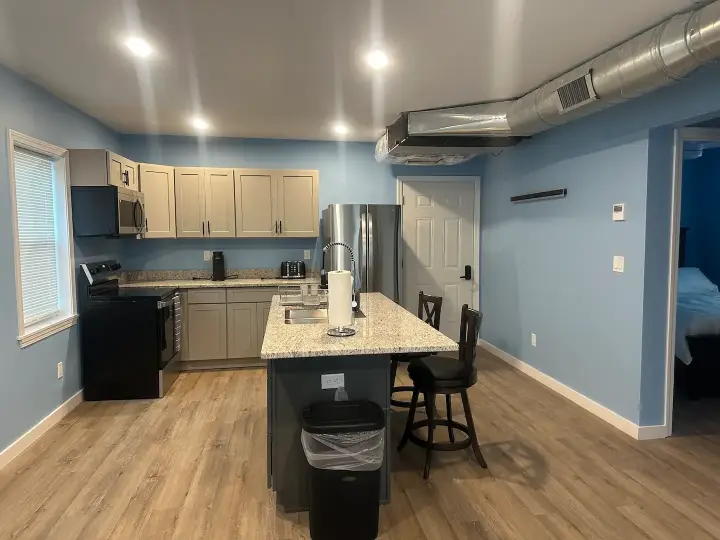 A kitchen with blue walls and wooden floors.