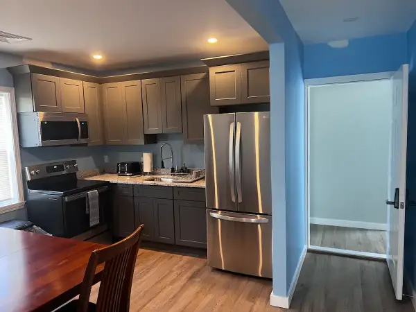 A kitchen with stainless steel appliances and wooden floors.