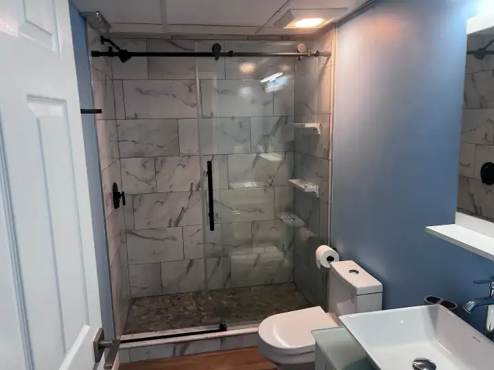 A bathroom with a toilet, sink and shower.