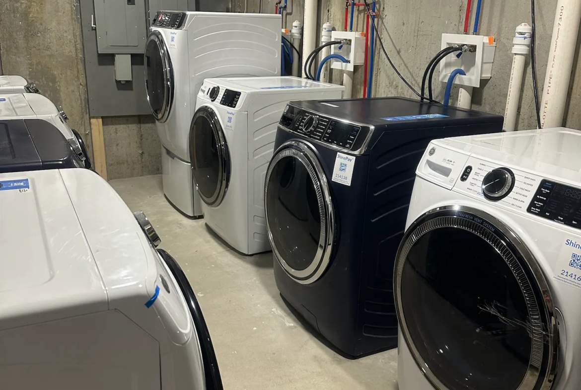 A row of washing machines in a room.