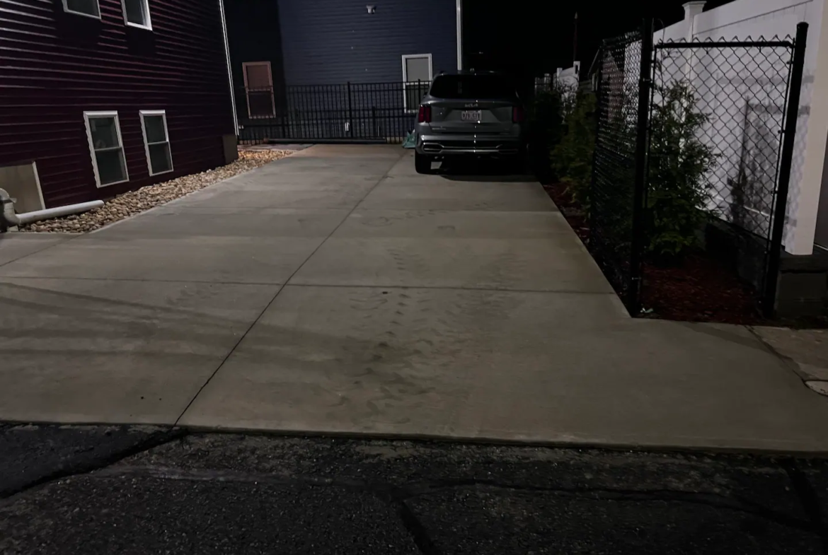 A car parked in the driveway of a house.