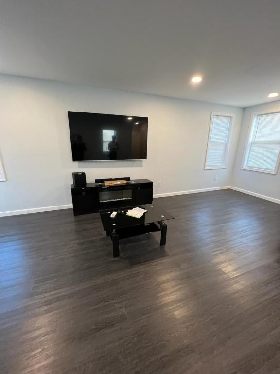 A living room with hard wood floors and a flat screen tv.