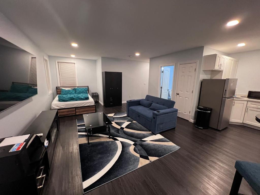 A living room with a couch, television and a bed.