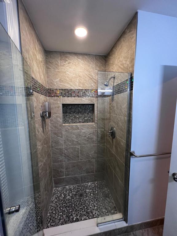 A walk in shower with tiled walls and floor.