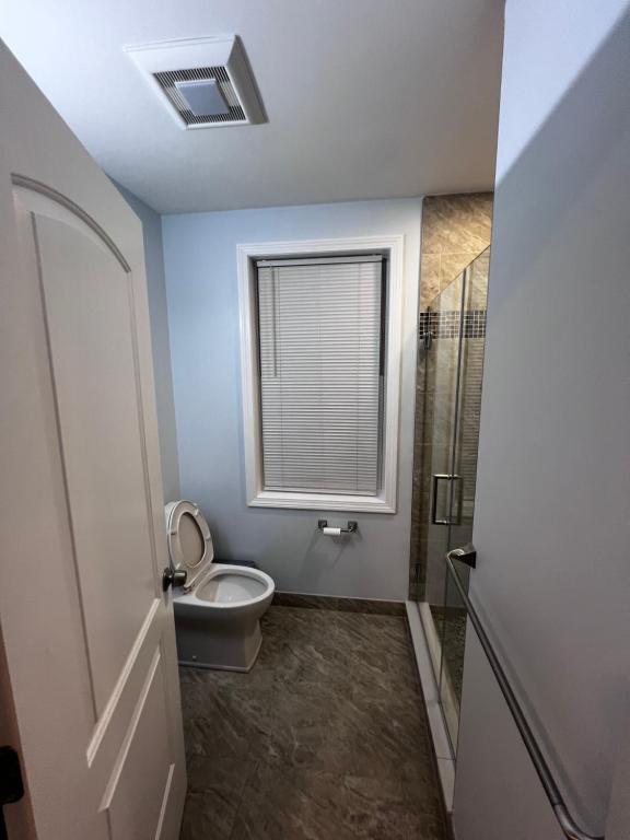 A bathroom with a toilet and shower stall.