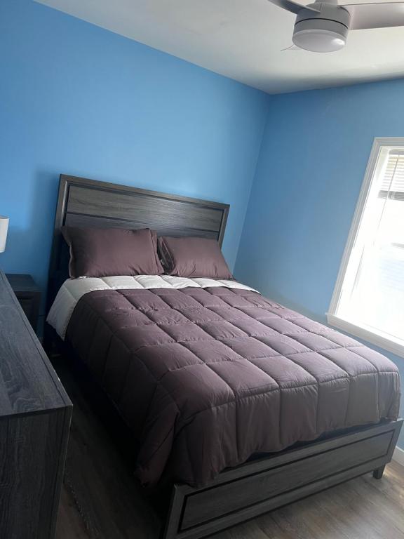 A bed room with a neatly made bed and a desk