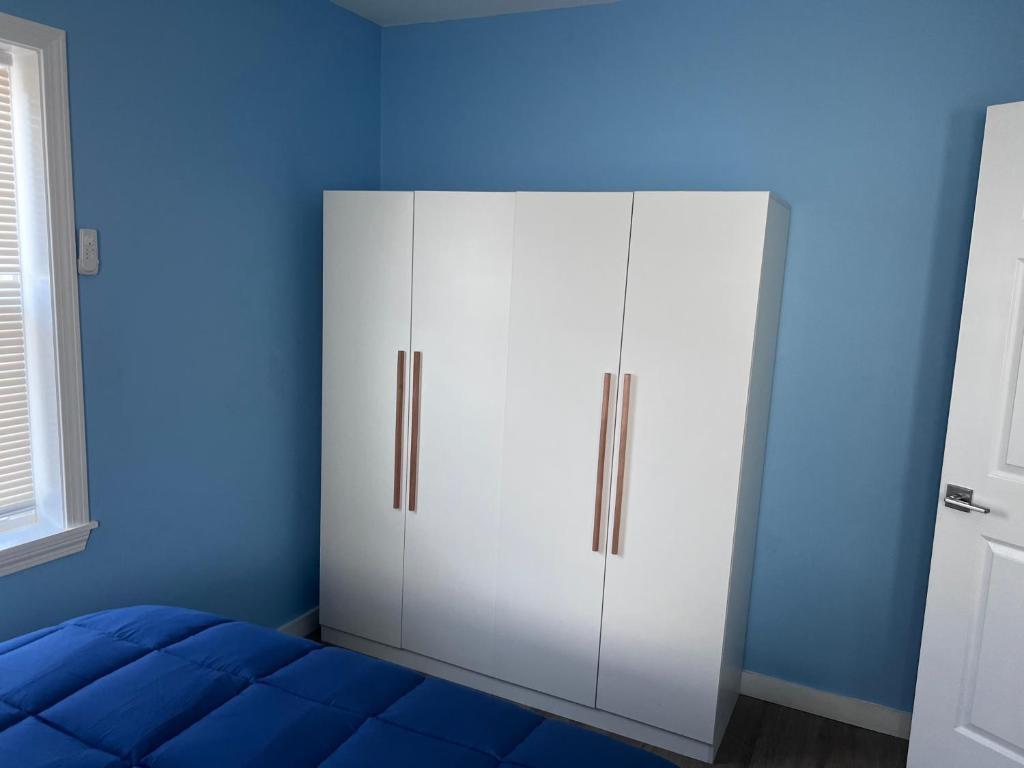 A white wardrobe in the corner of a room.