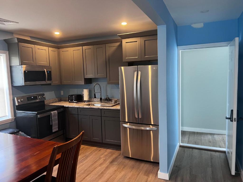 A kitchen with stainless steel appliances and wooden floors.