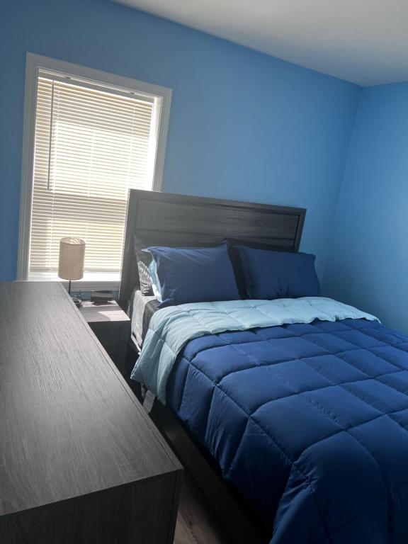 A bed room with blue walls and a black headboard