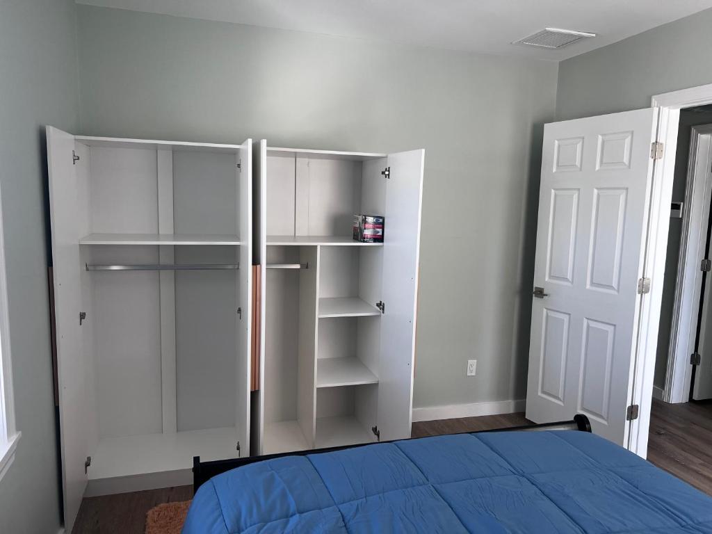 A bedroom with a bed and two white closets.