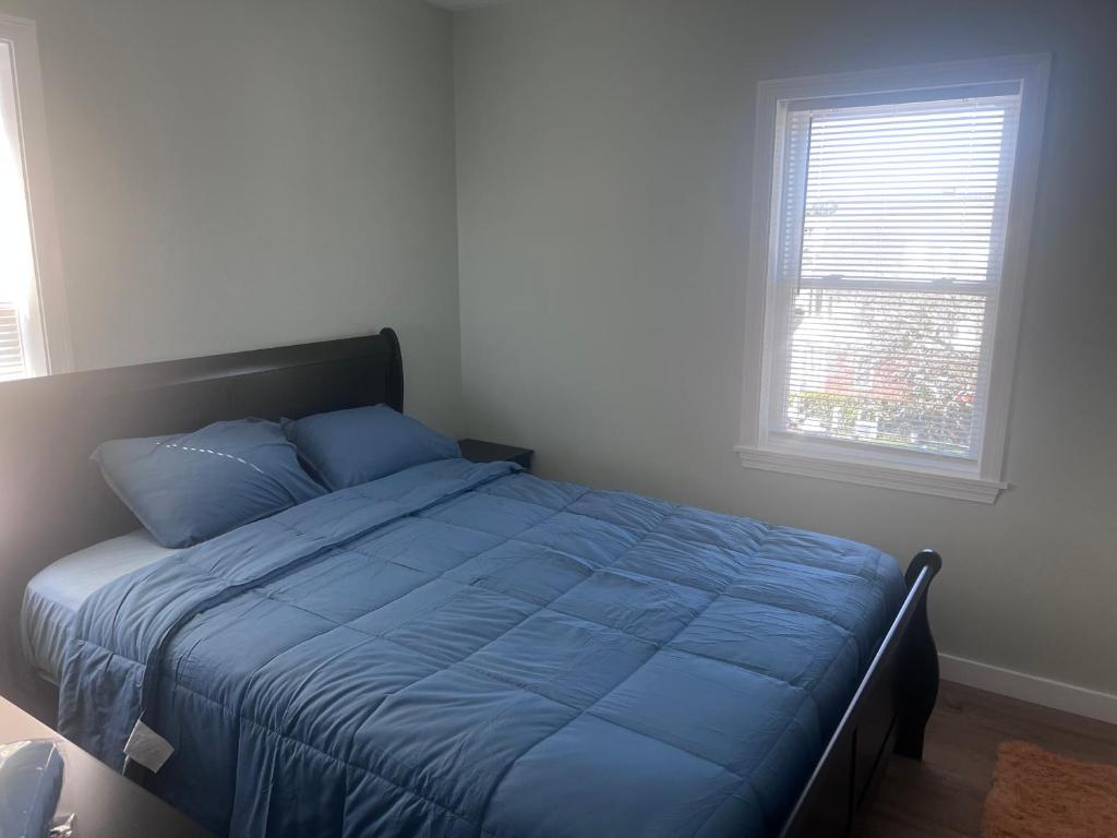 A bed room with a blue comforter and pillows