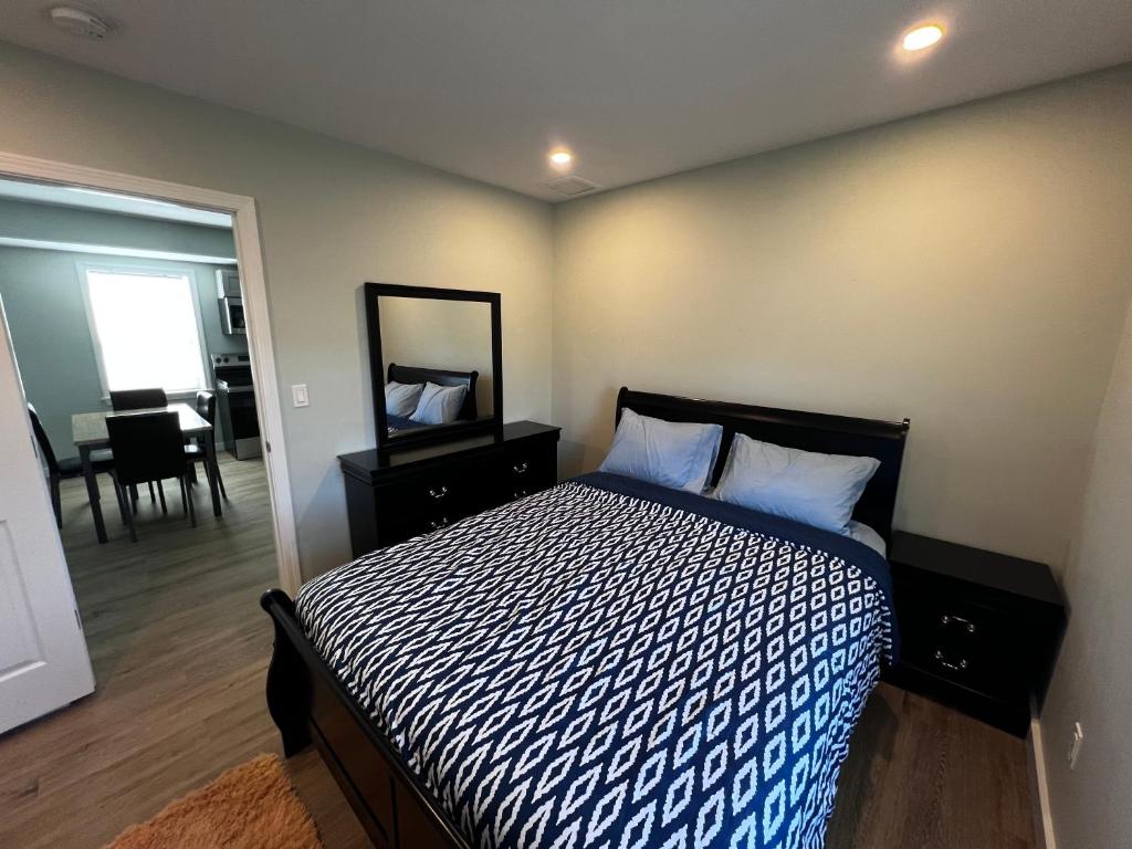 A bedroom with a bed, dresser and mirror.