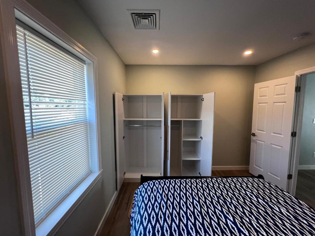 A bedroom with a bed, closet and window.