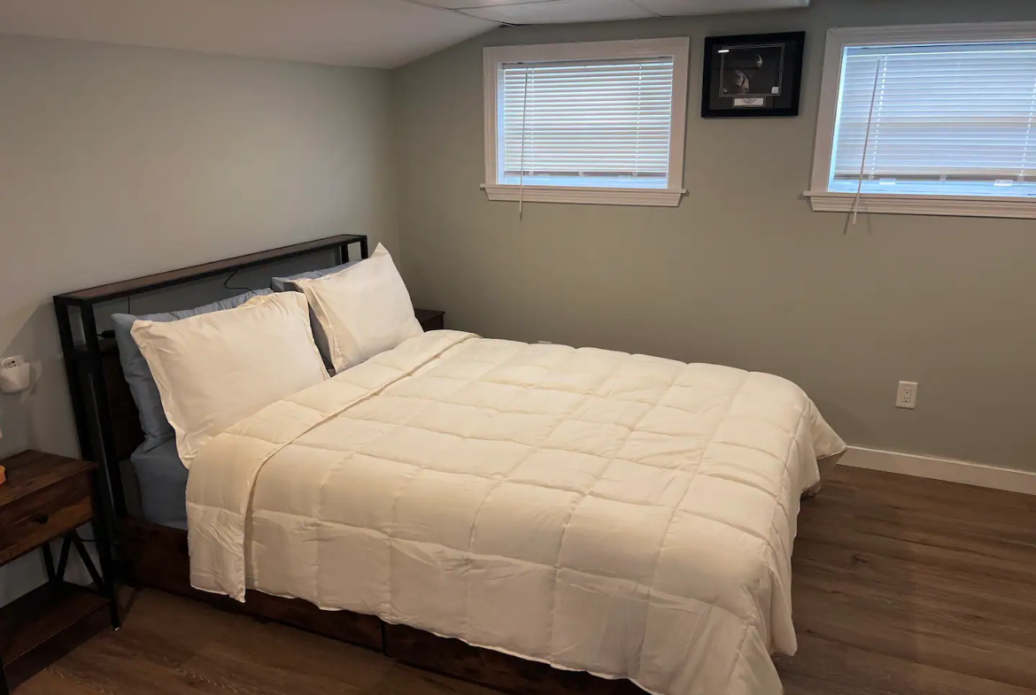 A bed room with a white bed and wooden headboard