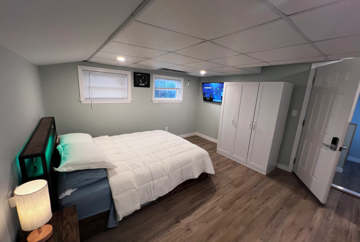 A bedroom with a bed, tv and dresser.