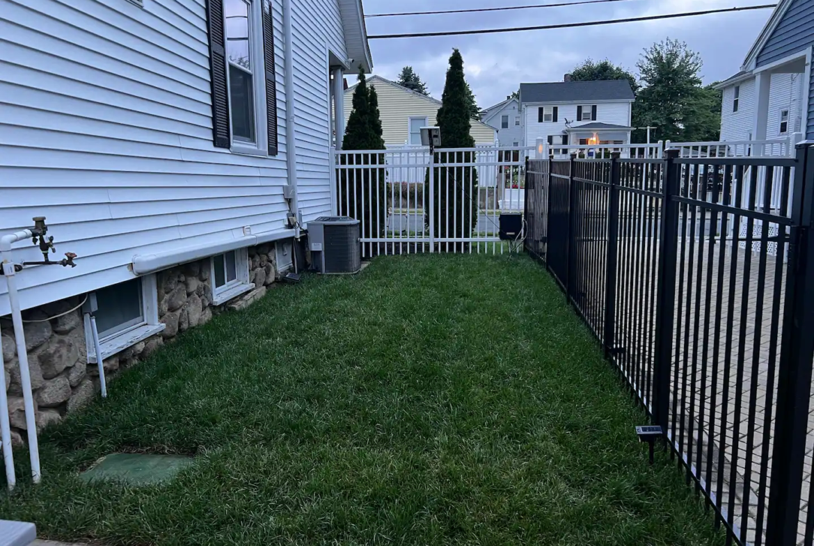 A yard with grass and trees in the background